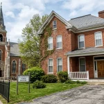 What is a Rectory in the Catholic Church? The Priest's Home Explained 2 A traditional brick Catholic rectory building located next to a parish church
